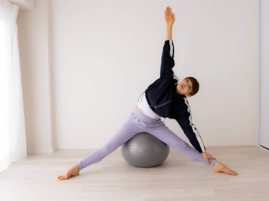 Güzel genç bayan pilates egzersizi yapıyor. 