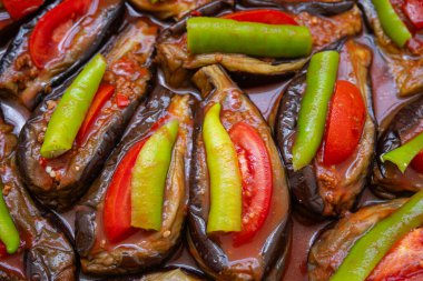 Baked eggplant stuffed with ground beef, tomatoes and green peppers on a tray. Traditional delicious Turkish food. Close-up