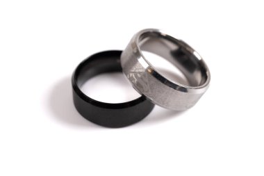 Two silver rings. White and black silver ring isolated on white background. Togetherness, wedding, love concept