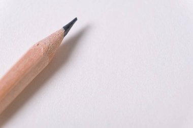 Notepad and wooden pencil. Minimalistic template with copy space, close up of wooden pencil on blank notebook paper, shallow depth of field