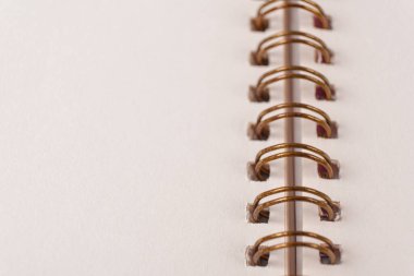 Blank spiral bound notebook. Close-up of blank paper notebook in a binder with metal ring binding, macro, real photo