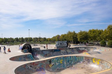 Istanbul, Turkey - 17 September, 2022: Skate park in outdoors. Skateboard area with bowls, ramps in the city public park, sunny summer day. Freestyle extreme sports. Outdoor activity for children