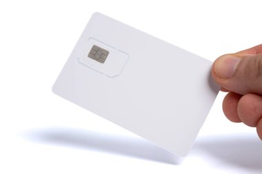 Elinde beyaz bir cep telefonu, SIM kart taşıyıcısı ve içine mikroçip yerleştirilmiş ambalaj.