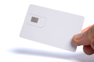 Elinde beyaz bir cep telefonu, SIM kart taşıyıcısı ve içine mikroçip yerleştirilmiş ambalaj.