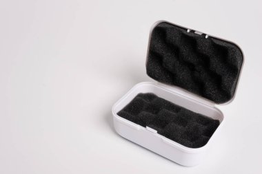 White open box lined with black sponge inside, isolated on a white background. Black mini pouch bag for storing small things. Inside of the protection bag