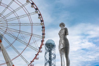 Batumi, Georgia - 18 Haziran 2023: Bulutlu bir gökyüzü ile Batumi 'de Ali ve Nino heykeli. Ünlü Ali ve Nino kinetik heykeli. Sevgi ve birliğin sembolü. Popüler ikonik turist cazibesi. Kalabalık..