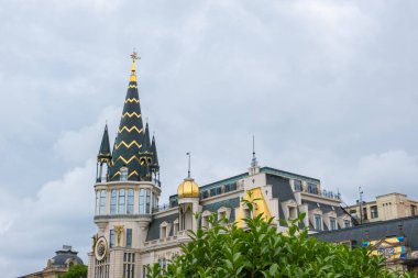 Batumi, Gürcistan - 18 Haziran 2023: Astronomik saat kulesi ve Avrupa 'da palmiye ağaçları olan tarihi bina. Mimari eğlence, dönüm noktası binası ve yemyeşil alan.