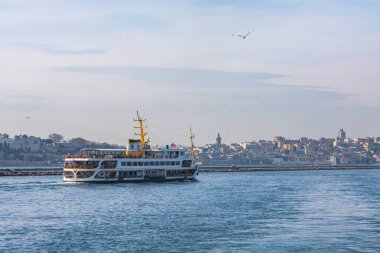 İstanbul, Türkiye - 10 Mart 2023: İstanbul 'da İstanbul Boğazı' ndan yolcu taşıyan feribot. Galata Kulesi manzaralı Marmara Denizi 'nde geleneksel feribot yolculuğu.