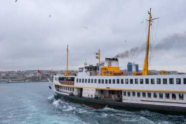 İstanbul, Türkiye - 10 Mart 2023: İstanbul arkaplanlı feribot İstanbul Boğazı 'nda denize açıldı. Feribot, tarihi ve ikonik siluet şehri ile Boğaz Boğazı 'ndan yolcu taşıyor.