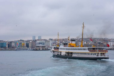 İstanbul, Türkiye - 10 Mart 2023: İstanbul arkaplanlı feribot İstanbul Boğazı 'nda denize açıldı. Feribot, tarihi ve ikonik siluet şehri ile Boğaz Boğazı 'ndan yolcu taşıyor.
