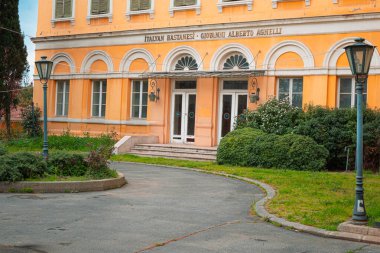 Beyoğlu, İstanbul, Türkiye - 23 Mayıs 2023: Sarı cepheli, büyük pencereli ve görkemli girişli terk edilmiş eski İtalyan hastane binası. Tarihi İtalyan hastane mimarisi