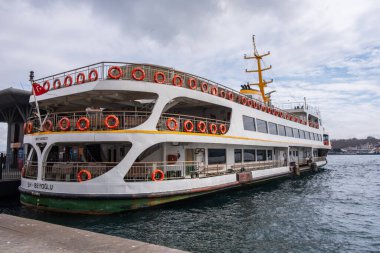 İstanbul, Türkiye - 10 Mart 2023: Feribot kalabalık metropol kentinde Karaköy iskelesine yanaştı. Bir feribot daha yanaşırken iskeleye yanaştı. Boğaz Boğazı arkaplanı
