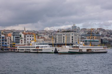 İstanbul, Türkiye - 10 Mart 2023: Feribot kalabalık metropol kentinde Karaköy iskelesine yanaştı. Bir feribot daha yanaşırken iskeleye yanaştı. Boğaz Boğazı arkaplanı