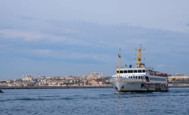 İstanbul, Türkiye - 10 Mart 2023: İstanbul arkaplanlı feribot İstanbul Boğazı 'nda denize açıldı. Feribot, tarihi ve ikonik siluet şehri ile Boğaz Boğazı 'ndan yolcu taşıyor.