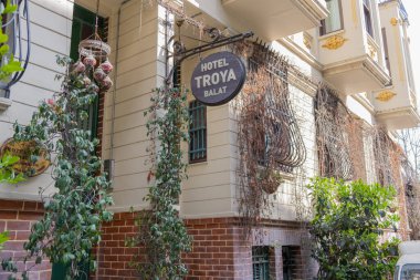 İstanbul, Türkiye - 10 Mart 2023: Butik ve İstanbul 'un tarihi Balat ilçesinde renkli ahşap kapılı geleneksel mimari otel. Renkli Balat mahallesindeki Troya Oteli 'nin önünde.