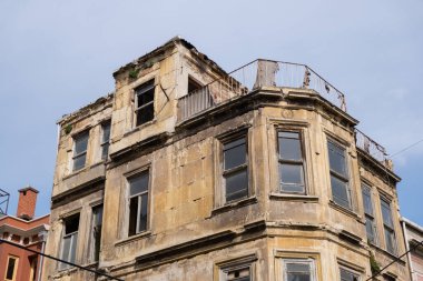Dilapidated, historic building with broken windows and crumbling facade. Abandoned, old, multi-story house structure with neglected balcony. Rich history, now in disrepair