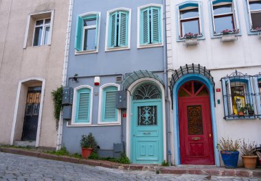 Colorful historic houses with ornate windows in Balat, Istanbul. Touristic district, attractions with historical sites. Colorful streets in Balat. Local and foreign tourists love this place