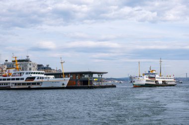 İstanbul, Türkiye - 10 Mart 2023: Feribot kalabalık metropol kentinde Karaköy iskelesine yanaştı. Bir feribot daha yanaşırken iskeleye yanaştı. Boğaz Boğazı arkaplanı