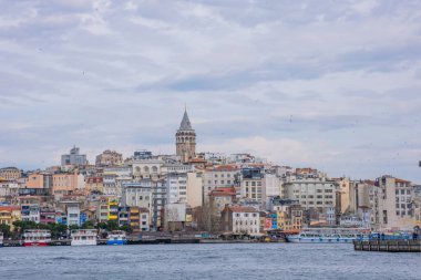 İstanbul, Türkiye - 10 Mart 2023: Galata Kulesi 'nin yer aldığı İstanbul Şehri, Altın Boynuz üzerindeki bir köprüden balıkçılık yapan insanlar