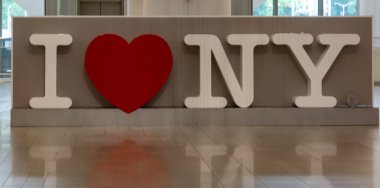 Cesur, sembolik bir New York tabelası. İçinde büyük beyaz harfler ve şehir için sembolik sembolik kırmızı bir kalp var. Seyahat ve şehir temalı içerik için ideal.