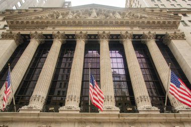 New York Borsası 'nın Amerikan bayraklarıyla olan ikonik cephesi finansal gücü ve tarihi mimariyi temsil ediyor. New York 'ta Wall Street' in özünü yakalıyor..