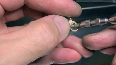 Yetenekli bir kuyumcunun hassas bir yüzüğü hassas aletlerle onarmasını izleyin. Restorasyon, çeşitli ekipmanlarla dolu temiz ve iyi aydınlatılmış bir atölyede gerçekleşiyor..