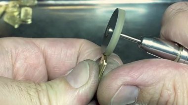 Bir modeli şekillendirmek ve rafine etmek için dönen bir alet kullanan yetenekli bir zanaatkarın yakın çekimi. Sessiz bir atölyede özenle hazırlanmış karmaşık detaylara odaklan..