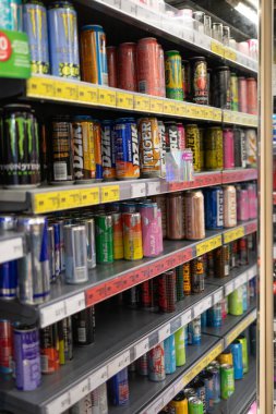 Enerji içecekleri bir mağazadaki rafları dolduruyor. Farklı marka ve renkler canlı bir görüntü yaratır. Müşteriler bu yerel dükkanda pek çok seçenek arasından seçim yapabilirler..