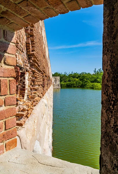 View from the loophole of the old fort to the old brick wall and moat, filled with water around the walls of the fort, Key West, Florida, US