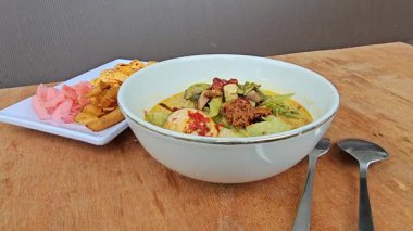 Batı Sumatra Endonezya 'dan Lontong sayur Padang, sebzelerle servis edilir; köri (Jackfruit, chayote, fasülye, eğreltiotu), haşlanmış yumurta, kızarmış tempeh, rendang, kırmızı kraker ve sambal.