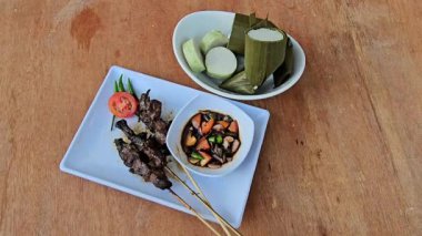 Sate kambing, Keçi eti sate, Keçi satay, koyun satay, Endonezya mutfağı soya soslu ızgara keçi eti, dilimlenmiş arpacık soğanı, dilimlenmiş cayyene biberi, doğranmış domates, salatalık ve lontong ile servis edilir. 