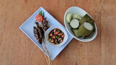 Sate kambing, Keçi eti sate, Keçi satay, koyun satay, Endonezya mutfağı soya soslu ızgara keçi eti, dilimlenmiş arpacık soğanı, dilimlenmiş cayyene biberi, doğranmış domates, salatalık ve lontong ile servis edilir. 