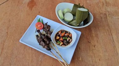 Sate kambing, Keçi eti sate, Keçi satay, koyun satay, Endonezya mutfağı soya soslu ızgara keçi eti, dilimlenmiş arpacık soğanı, dilimlenmiş cayyene biberi, doğranmış domates, salatalık ve lontong ile servis edilir. 