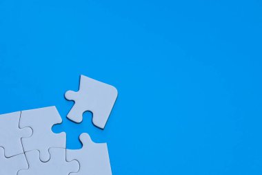 Beyaz yapboz parçası bulmacayı mavi kopya alanı ile tamamlamak üzere. Şirket birleşmesi ve satın alma kavramını temsil ediyor.