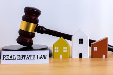 Hakimler minyatür evlerin yanı sıra mülkiyet hakları, hukuki anlaşmazlıklar, konut düzenlemeleri ve mülkiyet yönetimini temsil eden bir emlak hukuku sözcüğünün yanında tokmak gibi kalır.