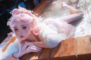 Sakin bir su bahçesinde, ruhani güzellikler saçan ve huzur içinde rüya gören bir kadının bu büyüleyici sahnesiyle kendinizi saf sükunete daldırın..