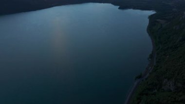 Göl yüzeyi günbatımını yansıtıyor. Fransa 'nın güneydoğusundaki Bourget Gölü etrafındaki sakin yaz havası ve dağ siluetleri. 