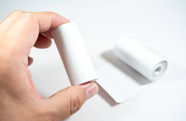 A hand holding a thermal paper roll, symbolizing the direct skin contact with the paper's chemical coating, which may contain BPA (Bisphenol A), an endocrine disruptor.