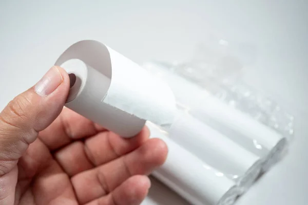 Kağıdın kimyasal tabakasıyla doğrudan teması simgeleyen termal kağıt rulo tutan bir el, BPA (Bisphenol A), bir endokrin parçalayıcı içeriyor olabilir..