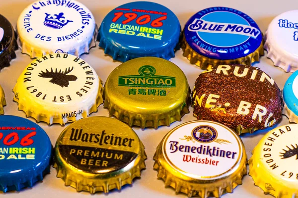 Çeşitli uluslararası ve yerli markaların renkli bira şişesi kapaklarının yakın plan çekimi..
