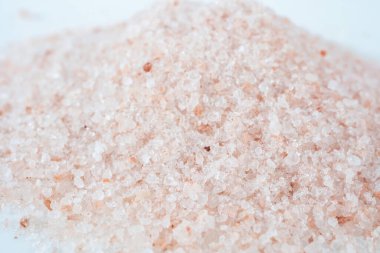 Beyaz arka planda pembe Himalaya tuz tanecikleri yığını. Yukarıdan çekilmiş..