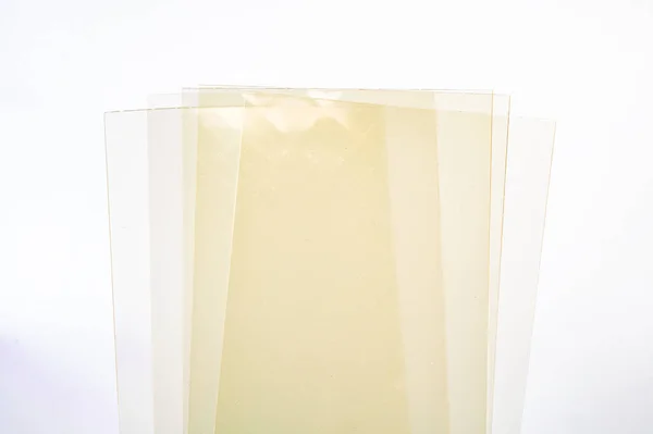 Beyaz zemin üzerinde bir yığın ince, yarı saydam jelatin yaprak (jelatin yaprakları), tatlı için gereklidir.