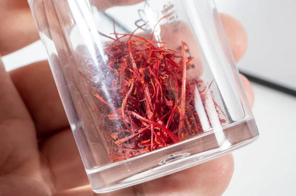 Temiz beyaz arka planda izole edilmiş küçük, canlı bir kırmızı safran iplik yığını (stigma).