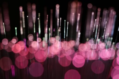 Kırmızı fiber optik ipliklerden oluşan soyut bir yakın plan, karanlık bir arka planda veri iletimi ve fütüristik teknoloji öneriyor..