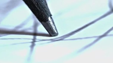 Kalem ucunu hareket halinde gösteren, grafit ve kağıdın dokusunu vurgulayan, yoğun bir odaklanma ve yaratıcı bir sürecin başladığını gösteren aşırı makro bir çekim.