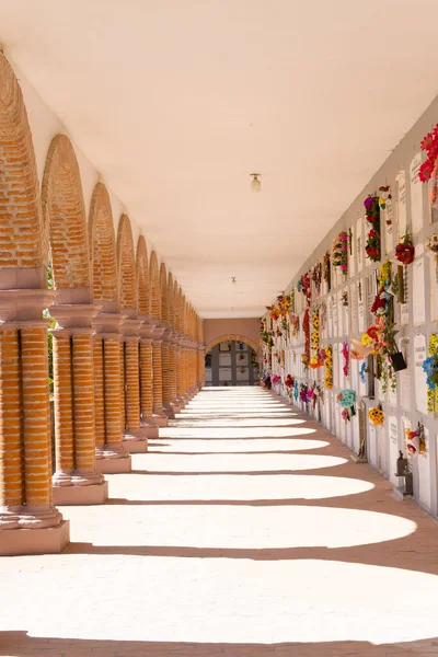 Turuncu tuğlalı mezarlık koridoru ve çiçekli duvar mezar taşları