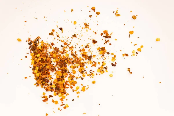 Beyaz bir yüzeye yayılmış acı biber taneleri, yakın çekim.