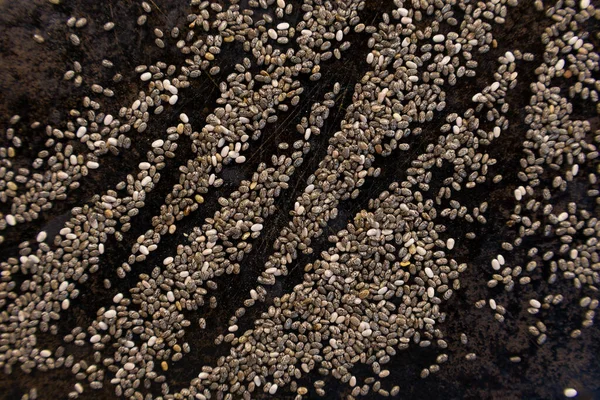 Siyah bir tava yüzeyinde chia tohumlarıyla çizilmiş zig zag