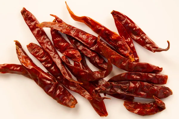 Sürüklenen kırmızı biberler (Şili de arbol) (Beyaz bir yüzeye dağılmış Capsicum anuum 'De rbol')