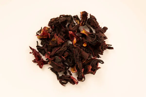 Kurumuş Hibiscus Sabdariffa (Jamaika çiçeği) beyaz bir yüzeye yakın bir daire çizer. 